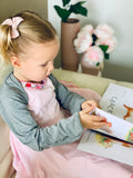 Toddler with open eczema mittens reading book
