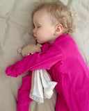 Baby sleeping in pink eczema sleeping bag with mittens